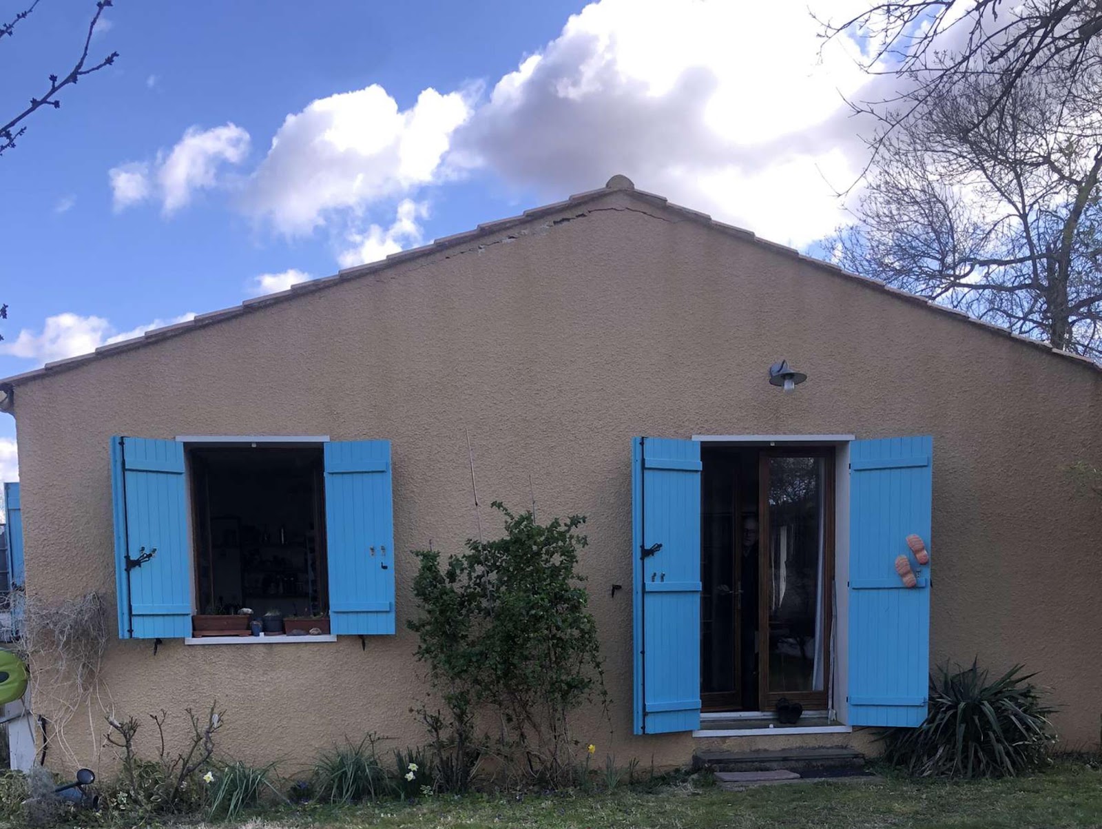Façade beige d'une maison aux volets bleus nettoyée dans le Var