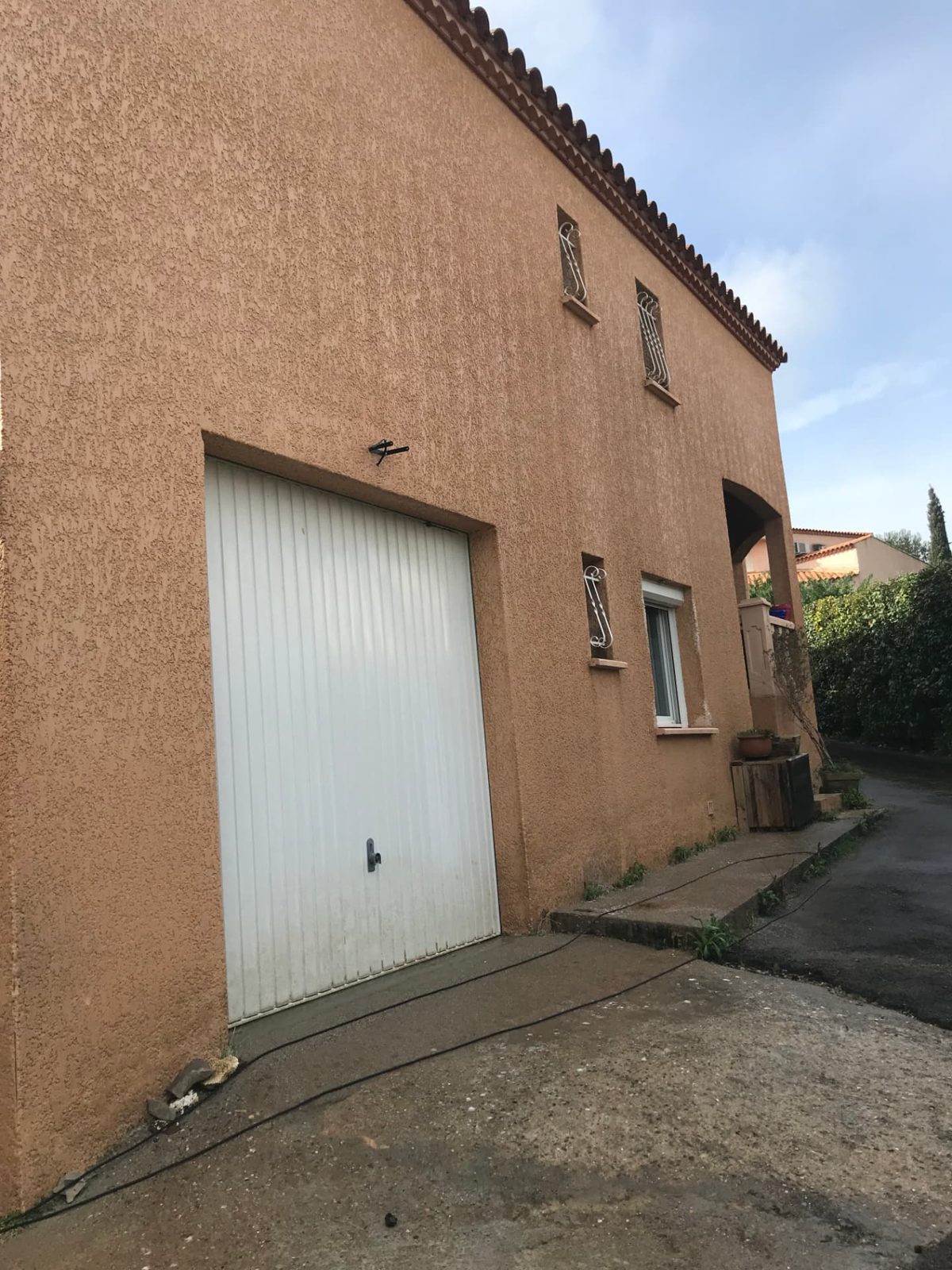 Même façade de garage à la teinte ocre retrouvée après nettoyage