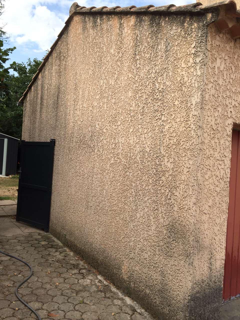 Mur pignon en crépi noirci par les mousses avant nettoyage